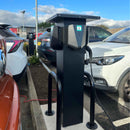 Shows the EVT110 installed outdoors with three compact EV chargers and protective bollards.